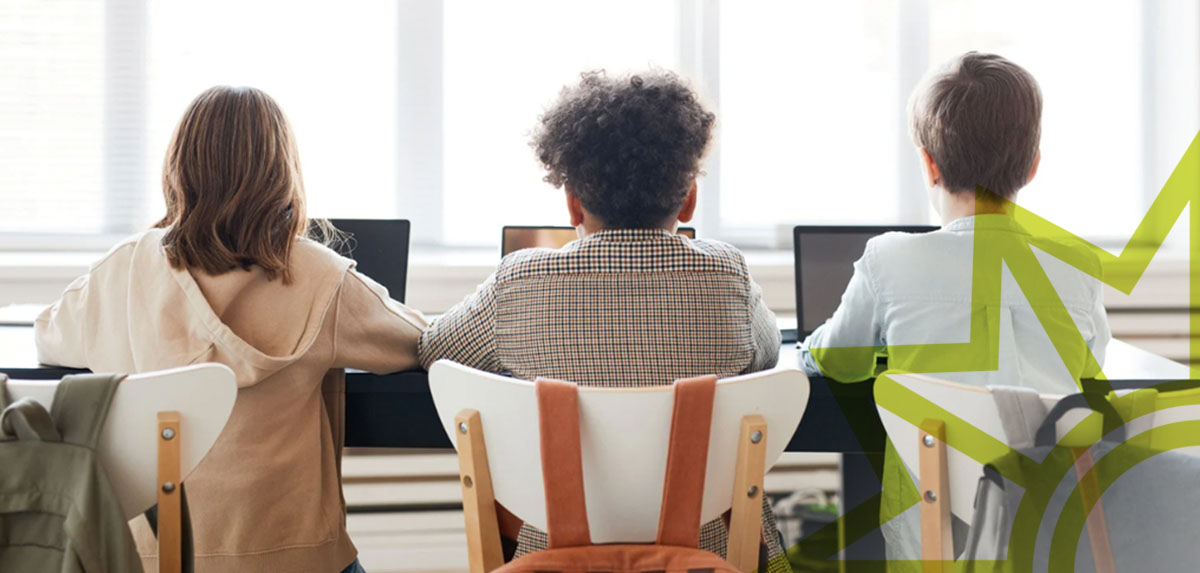 Kinder erwerben Medienkompetenz im Unterricht Drei Kinder sitzen nebeneinander an einem Tisch und arbeiten an Laptops, von hinten aufgenommen. Auf der rechten Seite ist ein grafisches, gelb-grünes Polizeistersymbol eingeblendet.