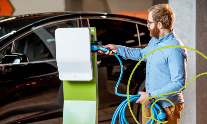 E-Autos gebraucht sicher kaufen Mann prüft Batterie eines E-Autos vor dem Gebrauchtkauf.